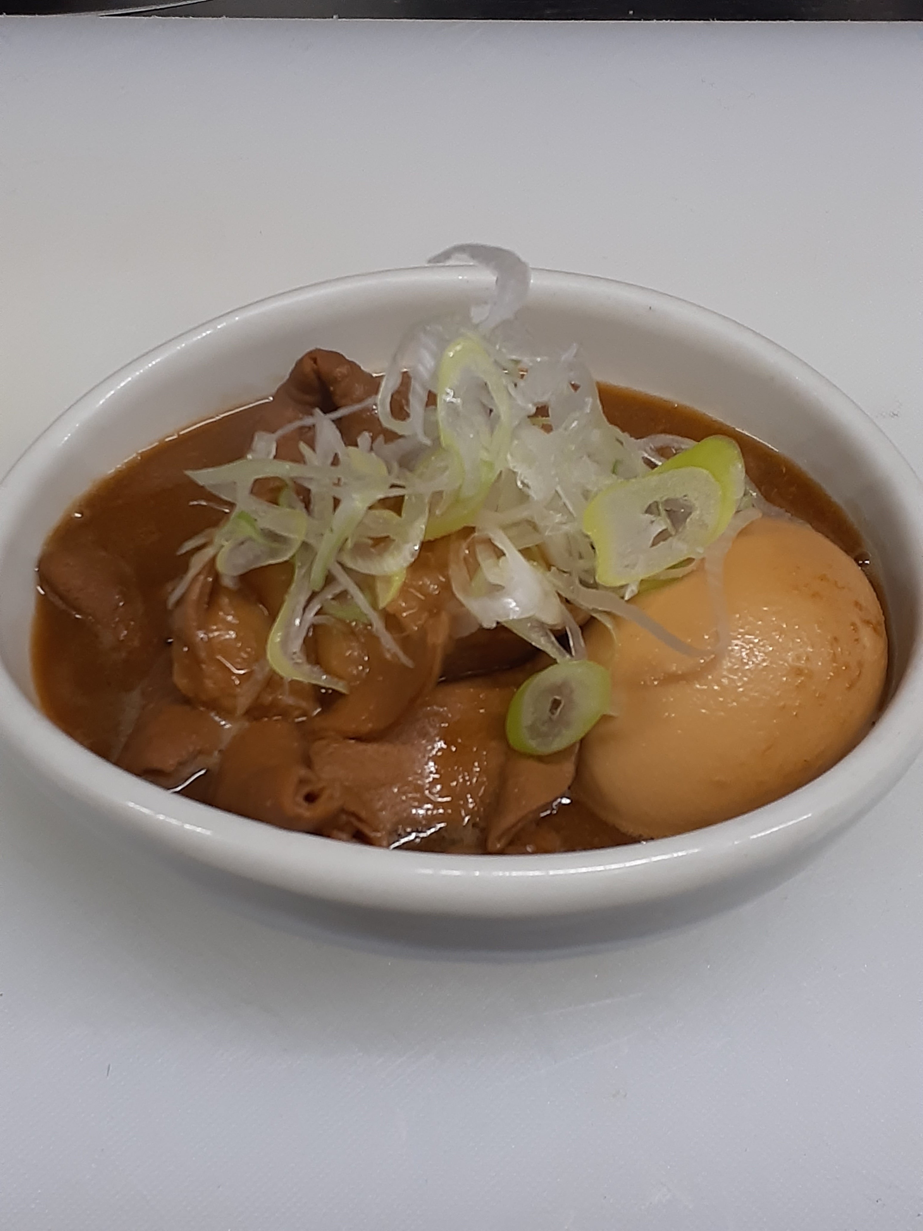 鮪と鮮魚と日本酒　百薬の玉子入りもつ煮込みの写真