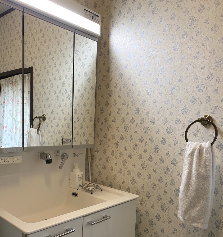 リフォームナビゲート ビオラの雰囲気の写真 - ブルーの小花の壁紙が可愛い、お気に入りの洗面所です。タオル掛けまで取り付けてくださいました。